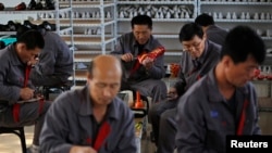 FILE - North Korean workers make soccer shoes inside a temporary factory at a rural village on the edge of Dandong October 24, 2012.