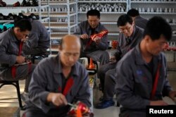 지난 2012년 10월 중국 랴오닝성 단둥의 한 마을에서 북한 노동자들이 신발을 만들고 있다. (자료사진)