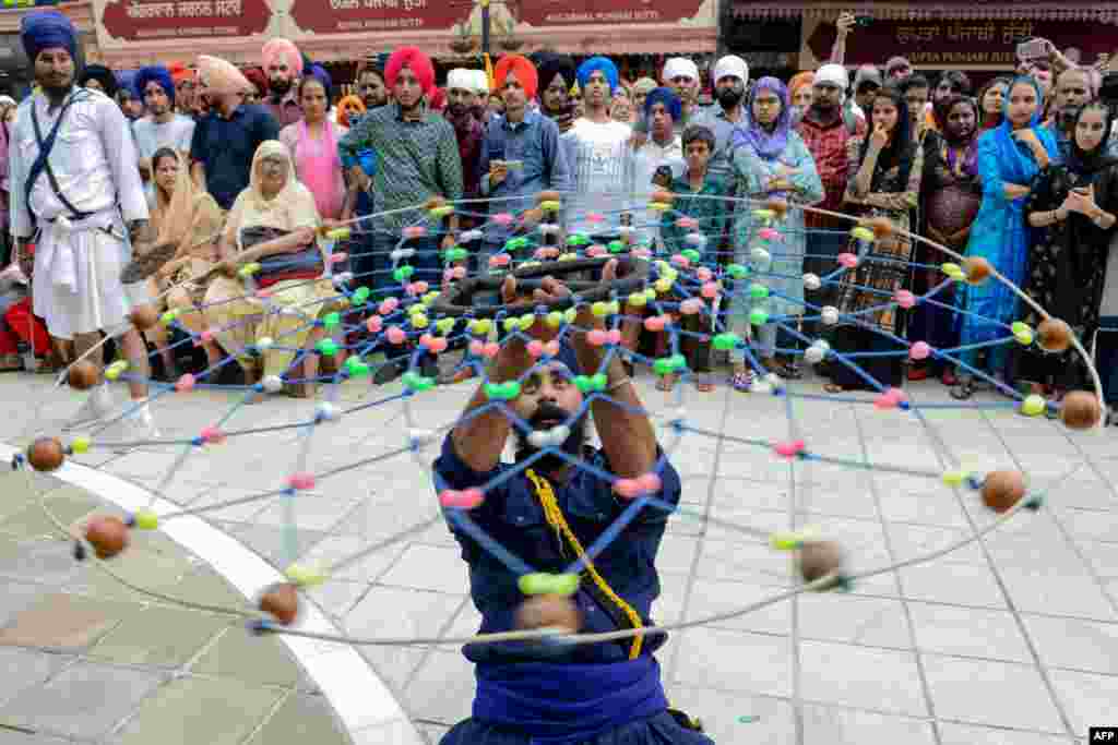A Sikh devotee demonstrates his &#39;Gatka&#39; traditional martial art skills during the &#39;Nagar Kirtan&#39; procession marking the 550th birth anniversary of Guru Nanak Dev, the founder of Sikhism, at the Golden Temple in Amritsar, India.