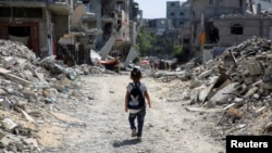 Seorang anak terlihat berjalan di antara puing-puing bangunan di Khan Younis, di selatan Jalur Gaza, pada 4 September 2024. (Foto: Reuters/Hatem Khaled)