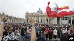 Pilgrims wave a Polish flag and sing as they gather in St. Peter's Square, at the Vatican, April 30, 2011, a day before late Pope John Paul II's beatification