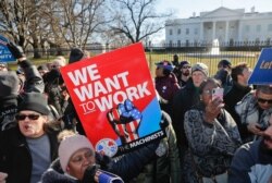 Union members and other federal employees stop in front of the White House in Washington during a rally to call for an end to the partial government shutdown, Jan. 10, 2019.