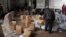 FILE - Aid parcels and boxes are offloaded from vehicles in a warehouse in Idlib, in northwestern Syria.