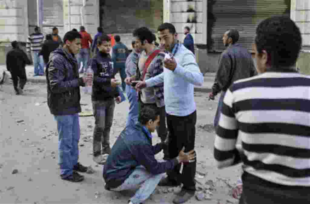 Volunteers check other anti-government protesters to search for and prevent weapons and infiltrators entering the demonstration after brief clashes with pro-government supporters in Talaat Harb square near Tahrir square in downtown Cairo, Egypt, Friday, F