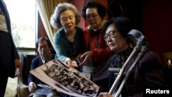 South Korean participants for a reunion check old pictures at a hotel used as a waiting place in Sokcho, South Korea, Oct. 19, 2015. The reunion of 90 South Koreans and 96 North Koreans, the 20th of its kind, will be held at a resort in the North.