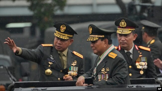 Menteri Pertahanan Prabowo Subianto (kanan) didampingi Panglima TNI Jenderal Agus Subiyanto (kiri) dan Kapolri Listyo Sigit Prabowo (kanan) memeriksa barisan dalam upacara di Mabes TNI, Jakarta, 28 Februari 2024. (Foto: Achmad Ibrahim/AP Photo)