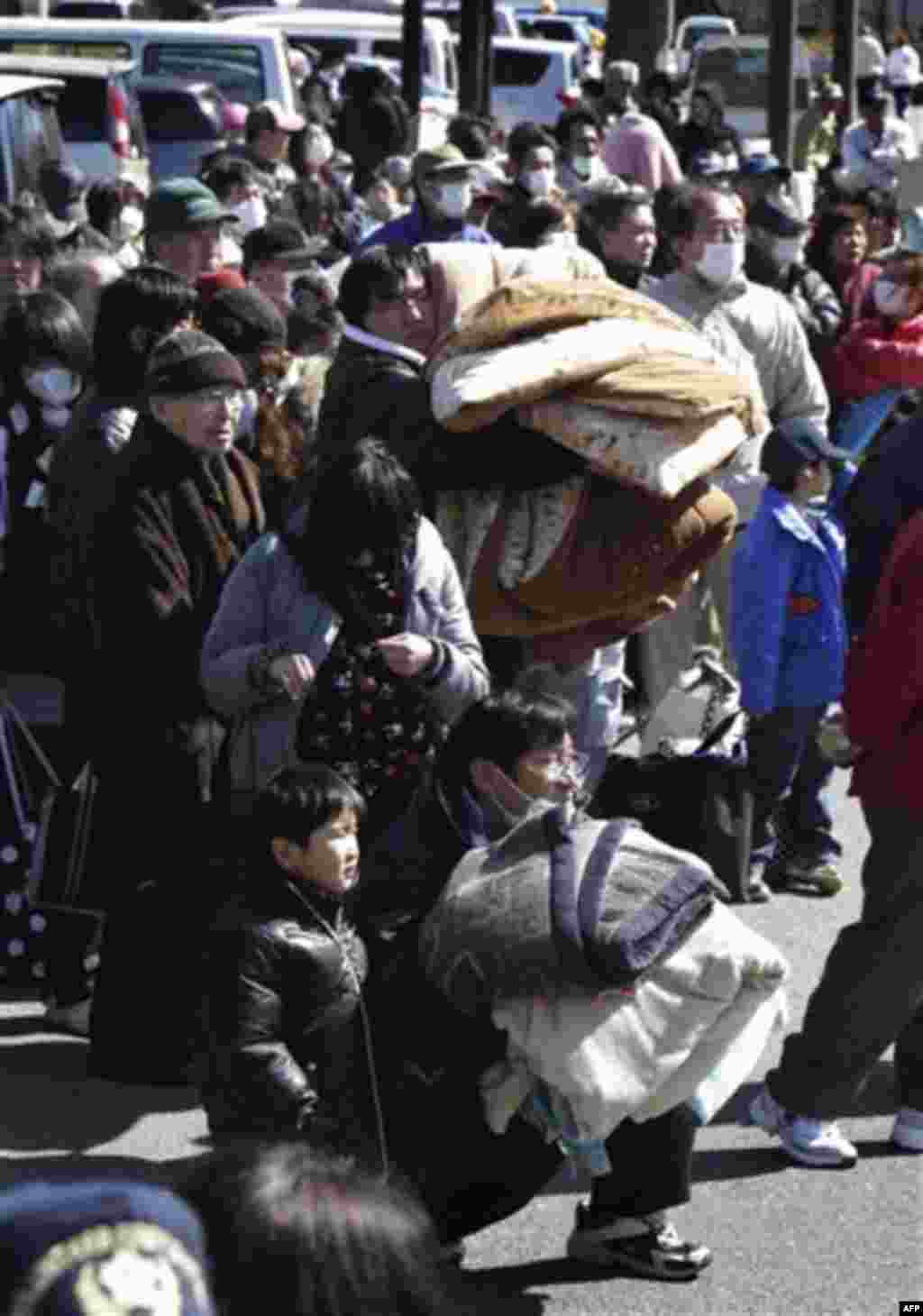 In this photo taken Saturday, March 12, 2011, residents gather at the Okumamachi Town Hall to evacuate from the Fukushima Dai-ichi nuclear plant area in Okumamachi, northern Japan, a day after a powerful earthquake-triggered tsunami hit the country's east