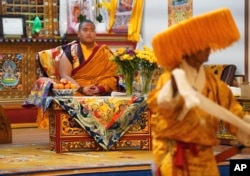 U.S.-born Buddhist lama, Jalue Dorje, watches a traditional Tibetan performance at his 18th birthday and enthronement ceremony in Isanti, Minnesota, Nov. 9, 2024.