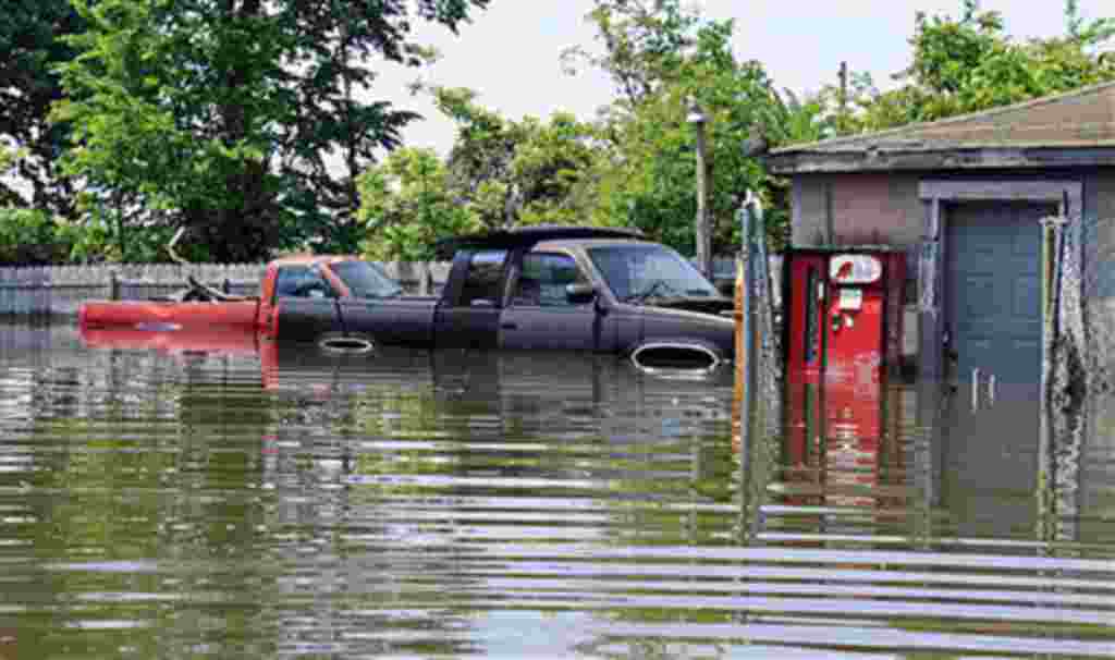 Dos camionetas se ven rodeadas de agua por la inundación del río Mississippi fuera de un garaje en Memphis, Tennessee, 8 de mayo de 2011.