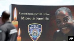 A Yankee Stadium security guard stands at attention as New York Police Department officer Miosotis Familia is memorialized before the start of a baseball game between the New York Yankees and the Toronto Blue Jays in New York, July 5, 2017.