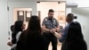 FILE - An officer listens to a question as he directs people to a courtroom in an immigration court in Miami, Florida, Jan. 10, 2024.