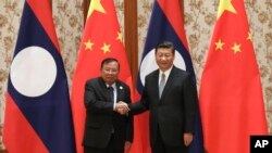 지난해 5월 중국을 방문한 분냥 보라칫 라오스 대통령(왼쪽)이 베이징 영빈관에서 시진핑 중국 국가주석과 만나 악수하고 있다.