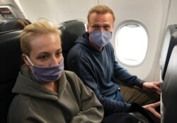 Kremlin critic Alexei Navalny and his wife Yulia are seen aboard a plane before their departure for Moscow at the Airport Berlin Brandenburg in Schoenefeld, near Berlin, Germany, Jan. 17, 2021.
