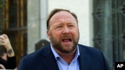 FILE--Alex Jones speaks to reporters in Washington, Sept. 5, 2018.