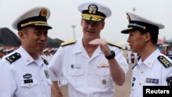 2014年8月5日美国第七舰队在青岛港: 舰队司令罗伯特·小托马斯（中）与中国北海舰队司令袁誉柏（左）