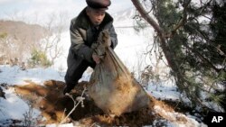 지난해 12월 북한 구장군 룡연리 주민이 한국전 참전 군인의 유해가 들었다고 주장하는 포대를 들어보이고 있다.