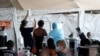 Health workers attend to patients in tents at the parking lot of the Steve Biko Academic Hospital, amid a nationwide coronavirus disease (COVID-19) lockdown, in Pretoria, South Africa, Jan. 11, 2021. 