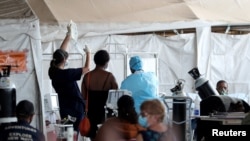 Health workers attend to patients in tents at the parking lot of the Steve Biko Academic Hospital, amid a nationwide coronavirus disease (COVID-19) lockdown, in Pretoria, South Africa, Jan. 11, 2021. 