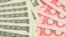Closeup of fanned US dollar and China yuan bills