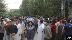 People stand outside after an earthquake is felt in Lahore, Pakistan, Sept. 24, 2019.