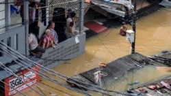 Foto udara menunjukkan warga di rumah mereka yang terendam banjir di kawasan Pasar Minggu, Jakarta, pada 4 Maret 2025. (Foto: AFP/BAY ISMOYO)