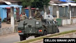 Des membres des Forces armées guinéennes traversent le quartier central de Kaloum à Conakry le 5 septembre 2021 après que des coups de feu aient été entendus.