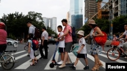 资料照：中国广州市天河区的父母送孩子上学。（2019年9月4日）