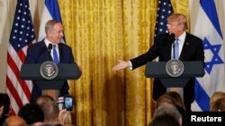 FILE - U.S. President Donald Trump, right, reaches out to Israeli Prime Minister Benjamin Netanyahu during a joint news conference at the White House in Washington, Feb. 15, 2017. 