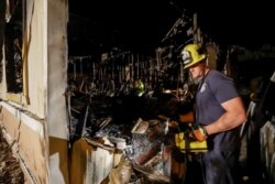 A fireman looks over a home Saturday, July 6, 2019 that burned after a earthquake in Ridgecrest, Calif.