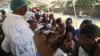 A health worker screens mothers and their children for possible symptoms of cholera in a quarantine area in Harare, Friday, Sept, 14, 2018, after a cholera emergency was declared following the deaths of more than 20 people.