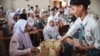 Siswa menerima piring makan siang pada hari pertama program makan gratis di SMA Negeri 11, Jakarta Timur, 6 Januari 2025. (Aditya IRAWAN / AFP)