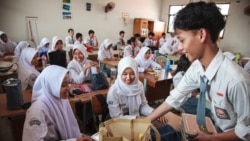 Siswa menerima piring makan siang pada hari pertama program makan bergizi gratis di SMA Negeri 11, Jakarta Timur, pada 6 Januari 2025. (Foto: AFP)