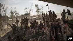 Iraqi Army soldiers gather to celebrate their gains as their fight against Islamic State militants continues in the Old City of Mosul, Iraq, July 9, 2017.