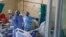 Deux infirmières sont vues à côté d'une machine qui vérifie les niveaux d'oxygène d'un patient A infecté par le COVID-19 au service numéro 20 de l'hôpital Tembisa de Tembisa, le 2 mars 2021 (Photo de Guillem Sartorio / AFP)