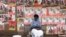 FILE - A woman sits in front of campaign posters in Nairobi, Kenya, April 26, 2017.