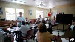 Alina Canel, nursing assistant, talks with the at the COVD-19 virus and how to care for themselves by washing their hands at Little Havana Activities and Nutrition Centers of Dade County, Inc., in Miami, March 4, 2020.