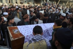 FILE - Afghans carry the coffin of a victim of a bombing and shooting attack, during his funeral, in Kabul, Afghanistan, Dec. 23, 2020.