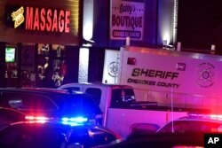 Authorities investigate a fatal shooting at a massage parlor, late March 16, 2021, in Acworth, Georgia.