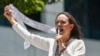 La líder opositora María Corina Machado muestra actas de recuento de votos durante una protesta contra la reelección del presidente Nicolás Maduro, en Caracas, Venezuela, el miércoles 28 de agosto de 2024. (Foto AP/Cristian Hernandez)