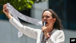 La líder opositora María Corina Machado muestra actas de recuento de votos durante una protesta contra la reelección del presidente Nicolás Maduro, en Caracas, Venezuela, el miércoles 28 de agosto de 2024. (Foto AP/Cristian Hernandez)