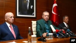 Turkey's President Recep Tayyip Erdogan, center, speaks to the media at Ataturk Airport before his departure for London for a two-day official visit, in Istanbul, May 13, 2018.