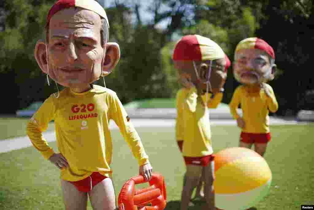 A protester, wearing a mask depicting Australian Prime Minister Tony Abbott and dressed as a lifeguard, calls for global equality among nations outside the venue site of the annual G20 leaders summit in Brisbane. Leaders depicted are (L-R) Australian Prime Minister Tony Abbott, South African President Jacob Zuma and Indian Prime Minister Narendra Modi.