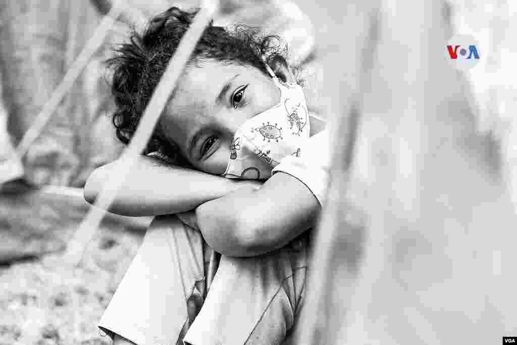 Mientas tanto, los ni&#241;os juegan en medio de las carpas y un canal de agua cerca del lugar.