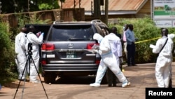 Forensic experts secure the scene of an attempted assassination on Ugandan minister of works and transport General Katumba Wamala, in the suburb of Kiasasi within Kampala, Uganda, June 1, 2021.