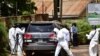 Forensic experts secure the scene of an attempted assassination on Ugandan minister of works and transport General Katumba Wamala, in the suburb of Kiasasi within Kampala, Uganda, June 1, 2021.