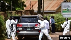 Forensic experts secure the scene of an attempted assassination on Ugandan minister of works and transport General Katumba Wamala, in the suburb of Kiasasi within Kampala, Uganda, June 1, 2021.