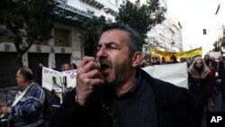 A protester chants slogans during a rally by health workers in Athens, Dec. 14, 2016. Workers in the country's health sector marched through the streets of the Greek capital to protest against government's planned reforms, which will affect their sector.