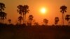 FILE - A sunset in Botswana's Okavango Delta. Trees silhouetted against a bright orange sky lit by a searing white disc is a typical sight for sunsets in the region, a popular destination for animal-watching safaris. 