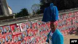 Une femme passe devant un mur couvert d'affiches électorales du Front de libération du Mozambique (Frelimo) lors du premier jour de la campagne avant les élections générales du 9 octobre, Maputo, le 24 août 2024.