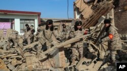 In this photo released by Xinhua News Agency, soldiers clear debris on the damaged houses after the earthquake in Chenjia Village of Dahejia Township, Jishishan County, northwest China's Gansu Province on Dec. 20, 2023. 